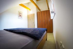 Ribnica na PohorjuAPARTMA NIKA的一间卧室配有一张床和一个木制橱柜