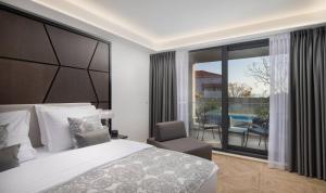 斯普利特Ellure Luxury Suites的一间带一张床和一把椅子的卧室以及一个阳台