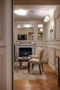 米兰Matilde Boutique Hotel的客厅配有椅子和壁炉