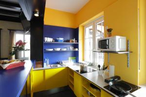 汉诺威廉价世博青旅的厨房拥有黄色和蓝色的墙壁,配有微波炉