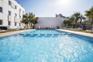 盖尼特拉Relax Hotel Kenitra的一座带椅子的游泳池以及一座建筑