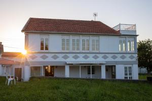 VillarrubeBeachfront Surf & Holiday House, up to 12 persons的一座白色的大房子,上面有阳光