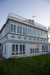 VillarrubeBeachfront Surf & Holiday House, up to 12 persons的白色的建筑,有很多窗户