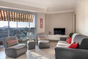 南特Appartement avec vue sur l'Erdre pour 4 personnes的客厅配有沙发、椅子和电视