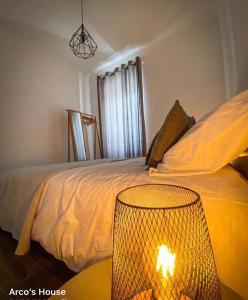 蓬塔德尔加达Arco´s Apartment 2的一间卧室配有一张床,旁边配有一盏灯