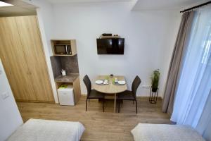 帕波Sport Centrum Apartman的小房间设有桌椅和厨房