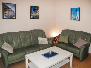 卢布明Holiday Home Strandvilla - LUB117 by Interhome的客厅配有两张绿色沙发和一张桌子