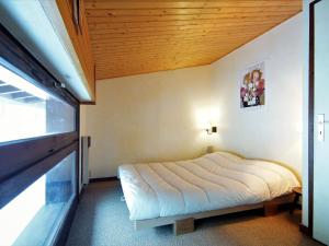夏蒙尼-勃朗峰夏蒙尼波拉尔尼斯II因特尔之家度假屋的一间卧室设有一张木天花板床。