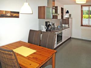 卢布明Apartment Strandvilla - LUB110 by Interhome的一间带木桌和椅子的厨房以及一间用餐室