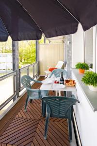 奥斯特西巴德钦诺维茨Apartment Zur Düne II by Interhome的阳台配有桌椅和遮阳伞。