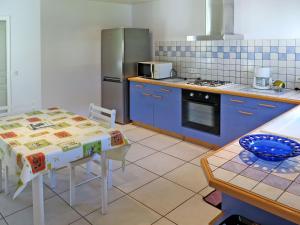 梅桑热Holiday Home Le Moïsan - MES120 by Interhome的厨房配有桌子和冰箱