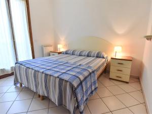 洛萨皮内塔Apartment Solmare-7 by Interhome的一间卧室配有一张床、梳妆台和两盏灯。