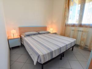 洛萨皮内塔Apartment Solmare-7 by Interhome的一间卧室配有一张带2个床头柜和2盏灯的床。