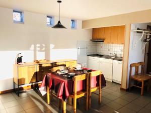 比特亨巴赫Holiday Home Au bord du Lac-1 by Interhome的厨房配有一张桌子,上面有红色的桌布