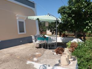 马丁纳弗兰卡Holiday Home Trullo Fior di Capperi by Interhome的一个带桌子和遮阳伞的庭院