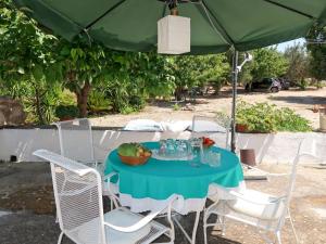 马丁纳弗兰卡Holiday Home Trullo Fior di Capperi by Interhome的雨伞下的桌子,上面放着一碗水果
