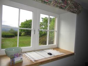巴洛赫Holiday Home Lorn Mill-3的客房设有2扇窗户和1张木桌。