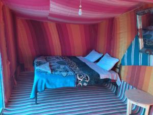 El GoueraChegaga Nomad Camp的帐篷内一间卧室,配有一张床