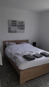 科尔讷巴里厄Magnifique maison avec baignoire balnéo的一张带白色床单和黑色枕头的床