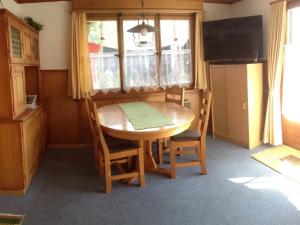 阿德尔博登桑内格鲁斯公寓的厨房配有木桌、椅子和电视