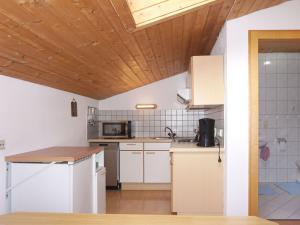 PiansApartment Quadratsch by Interhome的一间厨房,配有白色家电和木制天花板