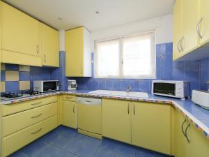 戛纳勒密涅瓦公寓的黄色的厨房配有水槽和微波炉