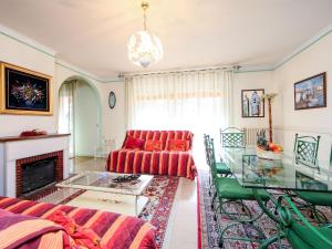 戛纳勒密涅瓦公寓的客厅配有红色的沙发和玻璃桌