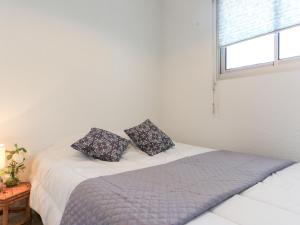 米尼赞海滩Apartment Grand Pavois-4 by Interhome的一间卧室配有一张带两个枕头的床