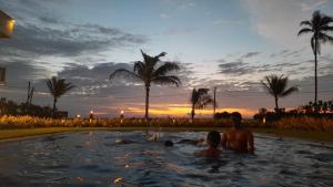 IranawilaCalypso Sunset的一群人在日落时分在游泳池里