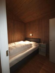 SurnadalSurnadal Camping Brekkøya的一间卧室设有一张带木墙的大床