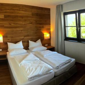 霍恩埃姆斯Hotel Café Schatz的一间卧室配有两张带白色床单和枕头的床。