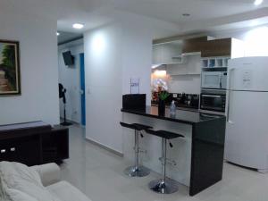 莫日-达斯克鲁济斯Apartamento completo A42 Flat Centro的厨房配有黑色柜台和白色冰箱。