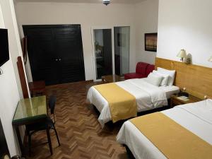 波帕扬卡米诺里奥波帕扬哥伦比亚酒店的酒店客房,配有两张床、一张桌子和一把椅子