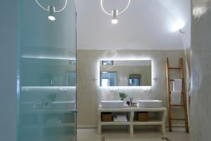 费拉U & ME SUITES的带淋浴、两个盥洗盆和镜子的浴室