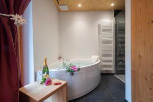 韦尔米廖白塔瓦伦酒店的带浴缸和一瓶香槟的浴室