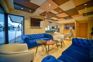 兹拉蒂博尔Aria Club Wellness&Spa Zlatibor的客厅配有蓝色的沙发和椅子