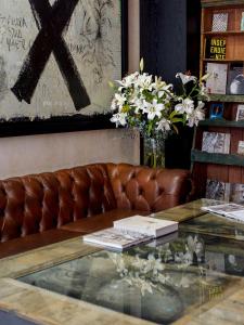 瓦哈卡市Casa Carmen Reforma的一张皮沙发,上面有花卉玻璃桌