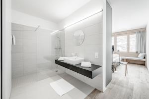 奥伯古格尔罗曼全包酒店的白色的浴室设有水槽和镜子