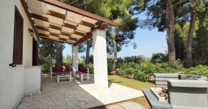 曼杜里亚Villa del Sole的一座房子内带木制凉棚的庭院