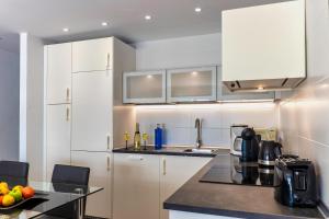 科斯塔特吉塞N E W 2021 My-Lanza the Luxury ONE的厨房配有白色橱柜和黑色台面