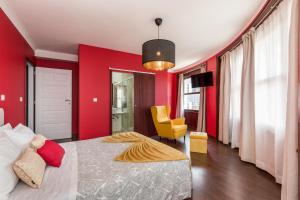波尔图Oporto Santa Catarina Residence的红色卧室配有床和黄色椅子