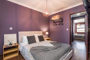 波尔图Oporto Santa Catarina Residence的一间拥有紫色墙壁的卧室和一张床铺