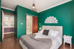 波尔图Oporto Santa Catarina Residence的绿色卧室,配有床和绿色的墙壁