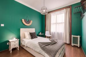 波尔图Oporto Santa Catarina Residence的一间卧室设有一张床和绿色的墙壁