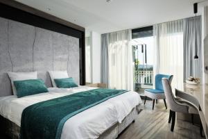 波斯托伊纳贾马酒店的一间卧室配有一张大床和一张桌子及椅子