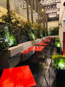 利马Radisson RED Miraflores的餐馆里一排种满植物的红桌