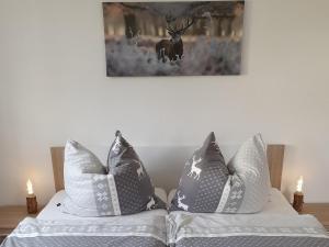 贝伦斯泰因Ferienwohnung "Waldzauber"的床上的2个枕头,墙上挂着鹿的照片