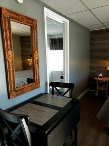 蒙特贝罗Motel Shantik的一间设有镜子、一张桌子和一张床的客房