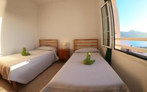 大塔拉哈尔Apartamento junto el mar的带窗户的客房内的两张床