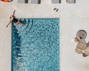 布拉卡Sea & Olives Suites Hotel and Villas的一个人在游泳池游泳